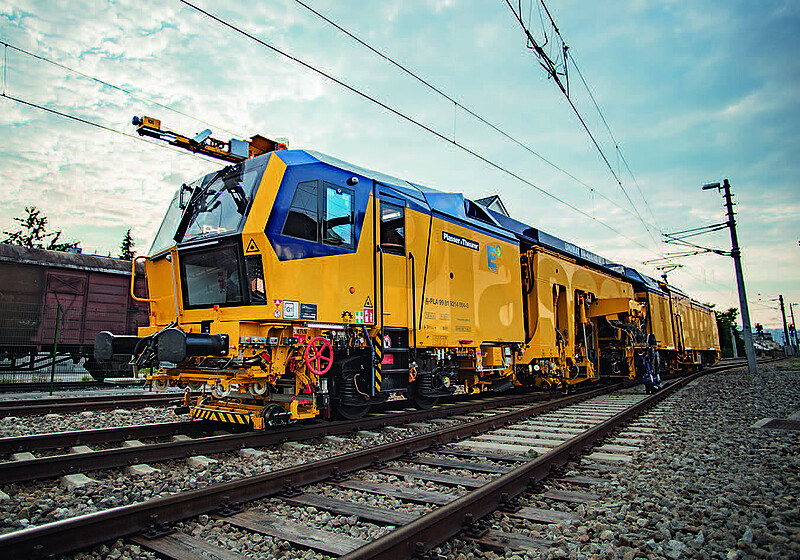 Yellow track maintenance machine outside on rails, equipped with a BIM interface inside.