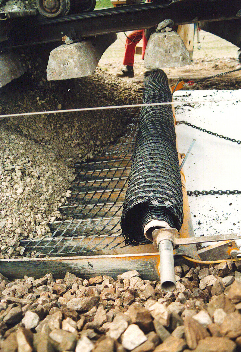 Track-bed layer with geogrid and geotextile